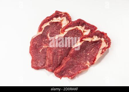 Trois steaks de bœuf crus sur fond blanc Banque D'Images