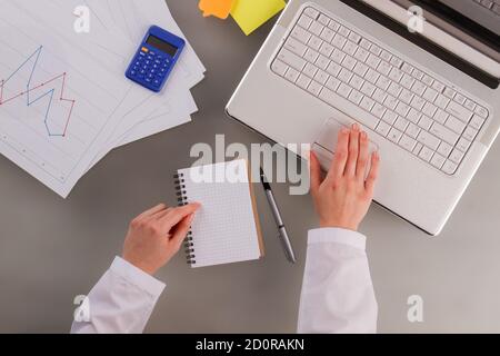 Mains d'une femme d'affaires travaillant sur un ordinateur portable au bureau. Banque D'Images