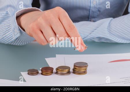 Femme d'affaires empilant des pièces sur la table pour économiser de l'argent. Banque D'Images