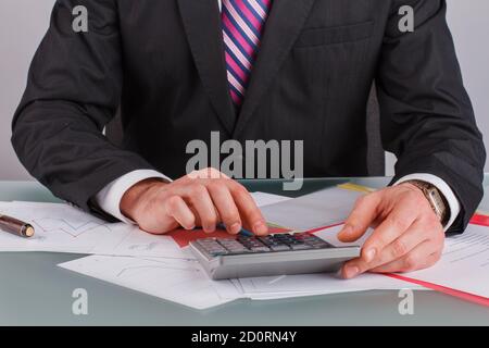 Homme d'affaires analysant les graphiques et les graphiques de revenus avec la calculatrice. Banque D'Images