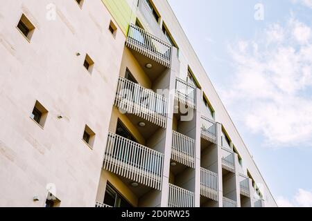 Un bâtiment avec de nombreux balcons avec une clôture blanche d'origine et de petites fenêtres sur le mur. Banque D'Images