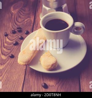 Tasse d'espresso chaud, moka pot et biscuits sur la table en bois Banque D'Images