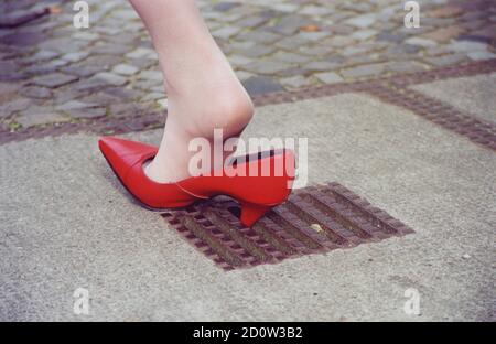 Malheur, la femme est coincée dans un trou aux talons hauts, Berlin, Allemagne, Europe Banque D'Images
