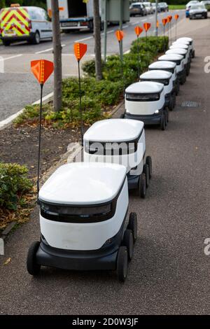 MILTON KEYNES, Royaume-Uni - 1 SEPTEMBRE 2020 : UNE ligne de robots de livraison automatisés sur le trottoir dans la banlieue de la ville britannique. Banque D'Images