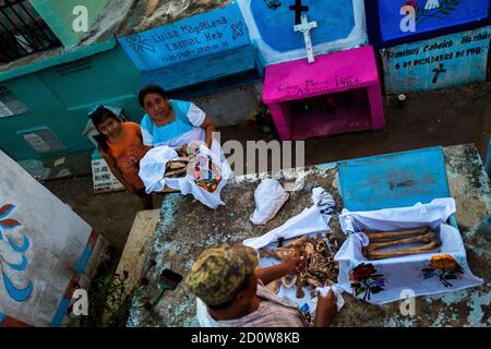 Les paysans mayas prennent soin des os asséchés d'un membre de la famille décédé lors du rituel de nettoyage des os au cimetière de Pomuch, au Mexique. Banque D'Images
