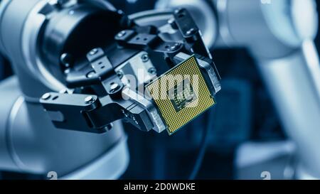 Modern High Tech Authentic robot Arm tenant le Super processeur d'ordinateur contemporain. Effecteur d'extrémité du manipulateur industriel tenant la puce de l'UC Banque D'Images