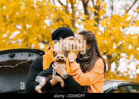 Un jeune couple aime ensemble dans la nature d'automne avec leur animal de compagnie Banque D'Images