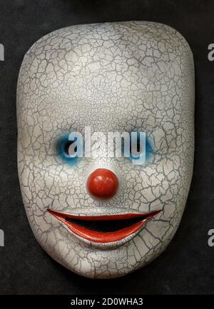 Moitié masque de visage Happy Clown isolé sur fond noir Banque D'Images