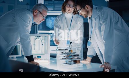 Tourné en laboratoire de conception industrielle, Spécialiste utilise le microscope, Designer Works sur ordinateur personnel, le chercheur écrit sur le tableau blanc de verre, équipe de Banque D'Images