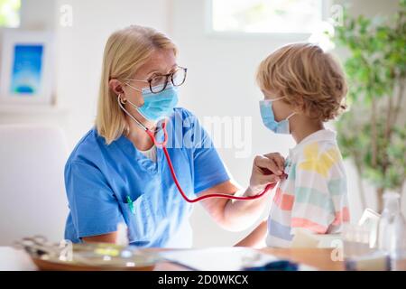 Vaccination contre le coronavirus. Vaccin Covid-19. Médecin vaccinant l'enfant. Enfants à la clinique. Un petit garçon se fait vacciner contre la grippe. Pédiatre examinant l'enfant et la givin Banque D'Images