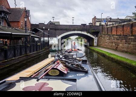 Une femme dirige un bateau à rames sous un pont sur le canal Bridgewater à sale, Manchester Banque D'Images