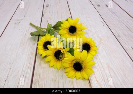 tournesols jaunes, fleurs artificielles colorées sur le fond du sol Banque D'Images