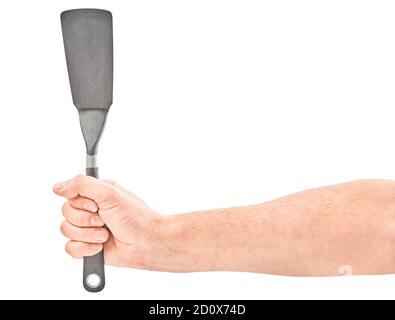 Mains de sexe masculin tenant une spatule pour la friture. Isolé sur fond gris. Banque D'Images