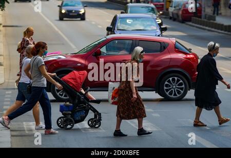 Bucarest, Roumanie - 30 juin 2020 : des piétons traversent la rue sur le boulevard Regina Elisabeta à Bucarest, Roumanie. Banque D'Images