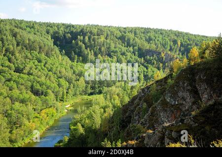 Une rivière calme qui traverse une forêt de conifères d'été dans un crevassé entre les montagnes. Berdsk Rocks, région de Novosibirsk. Banque D'Images