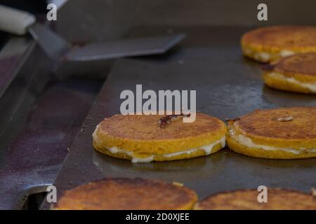 Plusieurs crêpes et flapjacks sur la cuisson au gril. Il y a une grande spatule sur le gril. Banque D'Images