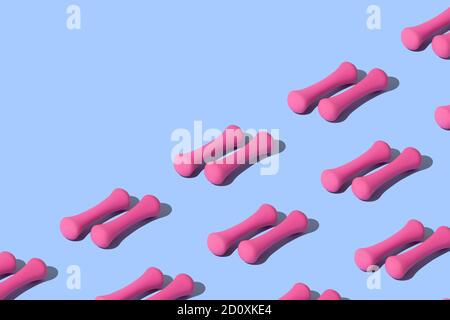 Motif sportif conceptuel avec haltère rose sur fond bleu avec place pour inscription. Banque D'Images