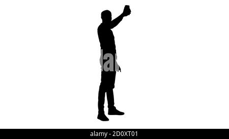 Silhouette Selfie Time ! Beau jeune homme prenant le selfie avec son téléphone. Banque D'Images