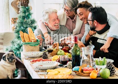 Les groupes familiaux déjeunent ensemble pendant la saison des jours de noël - happy caucasiens profitez de la nourriture et des activités de loisirs en intérieur à maison pendant les vacances tim Banque D'Images