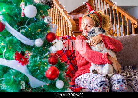 Vacances de Noël à la maison avec une bonne jeune femme caucasienne et drôle doux adorable chien de pug qui s'embrasse et s'amuser ensemble - amour pour le conc animal Banque D'Images