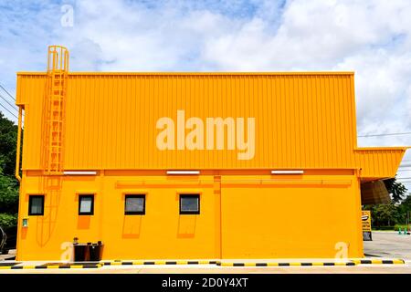 Vue latérale d'un grand bâtiment jaune sur fond ciel nuageux. Banque D'Images
