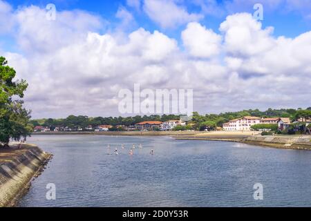 Groupe de personnes sur des planches à aubes allant de l'Hossegor canal au lac Banque D'Images