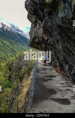 Femme solitaire marcheur, randonneur, sur l'ancien aqueduc qui fournissait de l'énergie aux travaux Auzat Pechiney aluminium, Ariège, France Banque D'Images