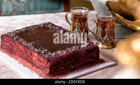 Gros plan sur le verre arabe et le gâteau rouge Banque D'Images