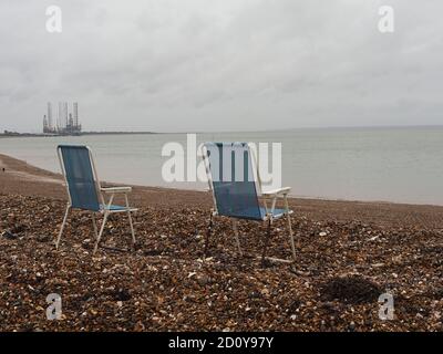 Sheerness, Kent, Royaume-Uni. 4 octobre 2020. Météo au Royaume-Uni : deux chaises pliantes abandonnées ressemblent un peu à une installation d'art conceptuel sur un octobre matin gris et humide à Sheerness, Kent. Crédit : James Bell/Alay Live News Banque D'Images