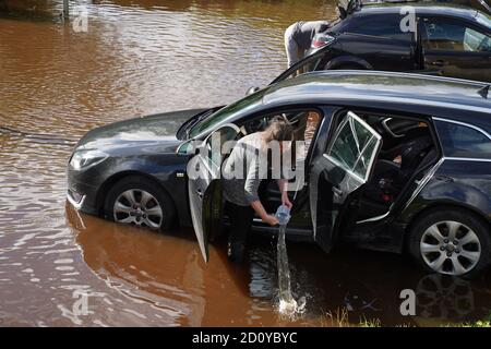 Un résident de Rothbury, dans le Northumberland, jette de l'eau de son véhicule après que le Coquet a fait éclater ses berges. Le week-end humide du Royaume-Uni se poursuivra, car un avertissement météo de pluie a été prolongé dans certaines parties du pays de Galles et de l'Angleterre. Banque D'Images