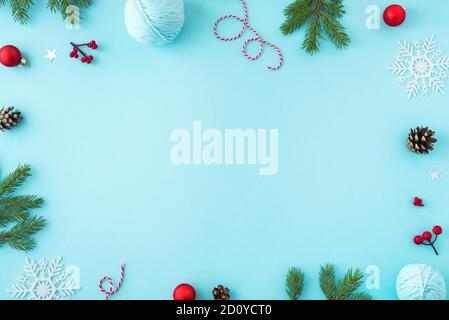 Composition de Noël. Décoration de Noël, pommes de pin, branches de sapin et flocons de douche sur fond bleu. Flat lay, vue de dessus, espace de copie. Banque D'Images