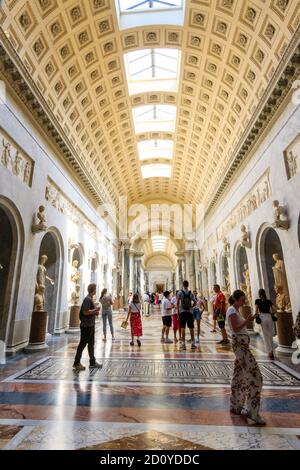 Personnes à la nouvelle aile de la galerie Chiaramonti, le Braccio Nuovo, avec ses bustes et ses statues de part et d'autre du couloir du Musée du Vatican. Banque D'Images