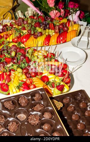 Buffet authentique, assortiment de fruits frais, baies et agrumes. Éclairage matinal, spot tendance et doux au foyer. Banque D'Images