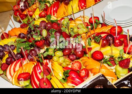 Buffet authentique, assortiment de fruits frais, baies et agrumes. Éclairage matinal, spot tendance et doux au foyer. Banque D'Images