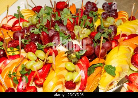 Buffet authentique, assortiment de fruits frais, baies et agrumes. Éclairage matinal, spot tendance et doux au foyer. Banque D'Images