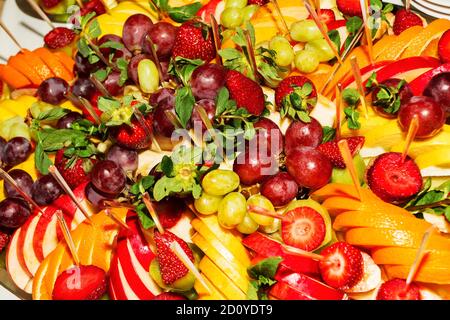 Buffet authentique, assortiment de fruits frais, baies et agrumes. Éclairage matinal, spot tendance et doux au foyer. Banque D'Images