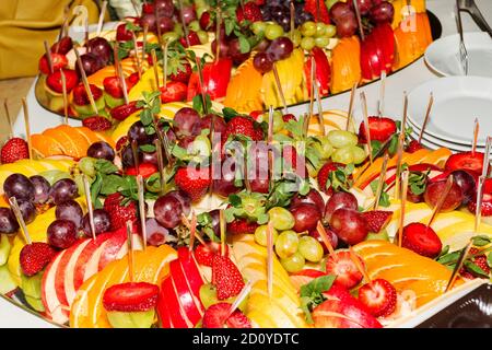 Buffet authentique, assortiment de fruits frais, baies et agrumes. Éclairage matinal, spot tendance et doux au foyer. Banque D'Images