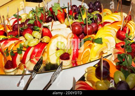 Buffet authentique, assortiment de fruits frais, baies et agrumes. Éclairage matinal, spot tendance et doux au foyer. Banque D'Images