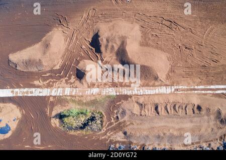 Vue aérienne en haut et en bas du champ de récolte de tourbe avec des tas de tourbe. Extraction de tourbe Banque D'Images