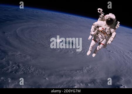 Astronaute marchant dans l'espace avec le fond de la terre, au-dessus d'un ouragan. Éléments de cette image fournis par la NASA. Banque D'Images