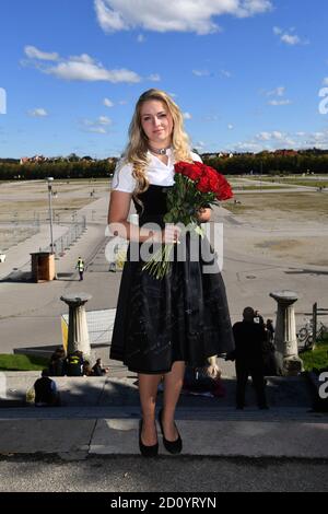 Munich, Allemagne. 04e octobre 2020. L'enfant de Munich Viktoria Ostler se tient dans un dirndl commémoratif noir pour la Wiesn 2020 annulée avec un bouquet de roses rouges sur les marches en face de la Bavière à la Theresienwiese. Credit: Felix Hörhager/dpa/Alay Live News Banque D'Images