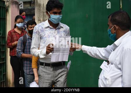 Guwahati, Assam, Inde. 4 octobre 2020. Examen de la Commission de la fonction publique du syndicat les candidats montrent leur preuve lorsqu'ils entrent dans un centre d'examen pour apparaître à l'examen préliminaire 2020 de la Commission de la fonction publique du syndicat (CSPU) à Guwahati Assam Inde le dimanche 4 octobre 2020. L'examen des services civils est un examen de concurrence national en Inde mené par la Commission de la fonction publique de l'Union pour le recrutement dans divers services civils du gouvernement de l'Inde, y compris le Service administratif indien, le Service extérieur indien, et le Service de police indien (crédit Imag Banque D'Images