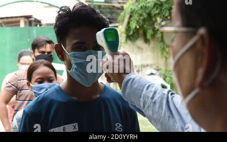 Guwahati, Assam, Inde. 4 octobre 2020. Examen de la Commission de la fonction publique du syndicat les candidats sont vérifiés leur température corporelle avant d'entrer dans un centre d'examen qui comparaîtra à l'examen préliminaire 2020 de la Commission de la fonction publique du syndicat (CSPU) à Guwahati Assam India le dimanche 4 octobre 2020. L'examen des services civils est un examen concurrentiel national en Inde mené par la Commission de la fonction publique de l'Union pour le recrutement dans divers services civils du gouvernement de l'Inde, y compris le Service administratif indien, le Service extérieur indien et le Pol indien Banque D'Images