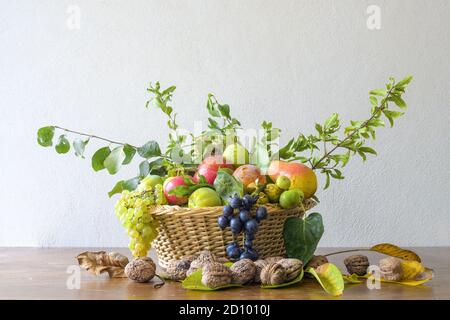 Automne nature concept, beau assortiment de fruits dans un panier sur une table en bois. Composition d'une variété de fruits biologiques crus. Banque D'Images