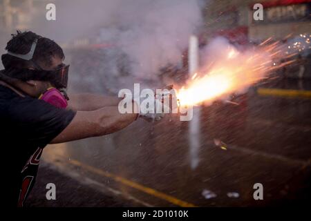 Santiago, Chili. 03ème octobre 2020. L'homme lance des feux d'artifice lors de la manifestation à Santiago.des centaines de manifestants affrontent la police dans les environs de la Plaza Baquedano, rebaptisée « Plaza de la Dignidad » par le peuple pour demander justice à Antoni, un homme de 16 ans qui a été jeté d'un pont par la police le jour de la manifestation précédente. Crédit : SOPA Images Limited/Alamy Live News Banque D'Images