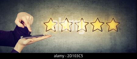 Excellent concept de service à la clientèle. Homme donnant cinq étoiles dans l'enquête en ligne à l'aide d'un gadget mobile Banque D'Images