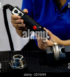 Les travailleurs industriels utilisent le dispositif de revêtement/revêtement laser Electro-Spark pour remplacer la pièce à usiner usée Banque D'Images