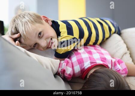 Les enfants sont heureux de jouer sur le canapé. Banque D'Images