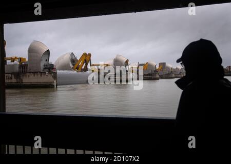 Un homme passe devant la barrière de la Tamise dans l'est de Londres, qui est fermée pendant sa fermeture annuelle d'essai complet. Les portes de la barrière pivotent de 90 degrés dans la position de défense entièrement fermée, ce qui arrête la marée qui va en amont vers Londres. Banque D'Images