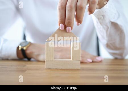 Femme construire la maison à partir de cubes en bois sur la table. Banque D'Images